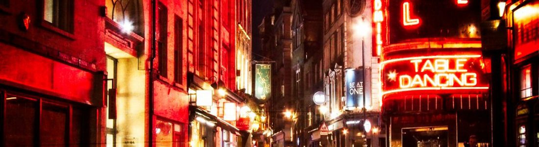 A street in Soho lit up at night